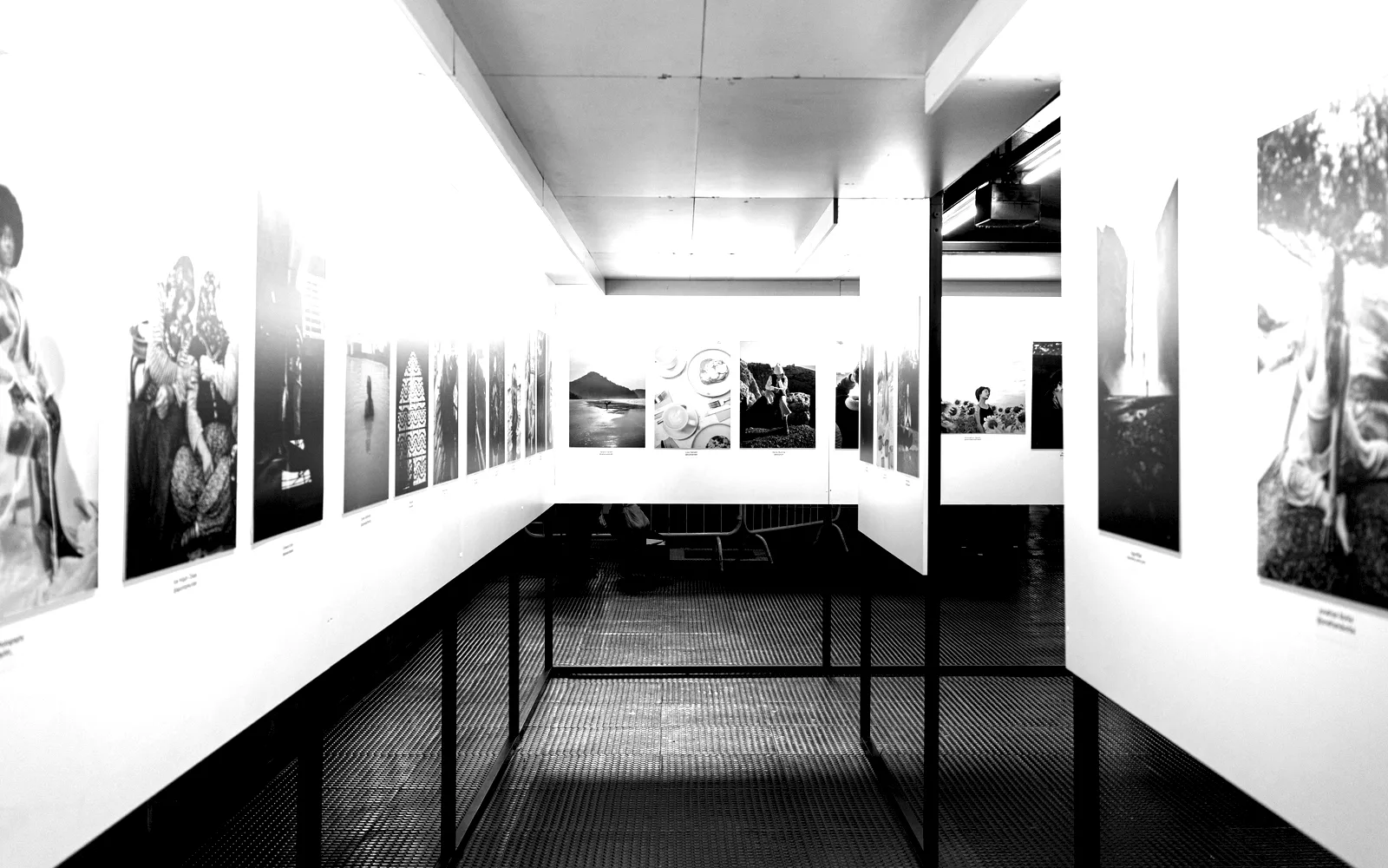 A long gallery wall hung with framed prints receding to a vanishing point.