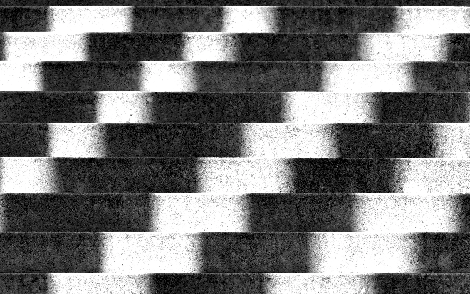 Raking light throwing hard diagonal shadows across a flight of stone steps.