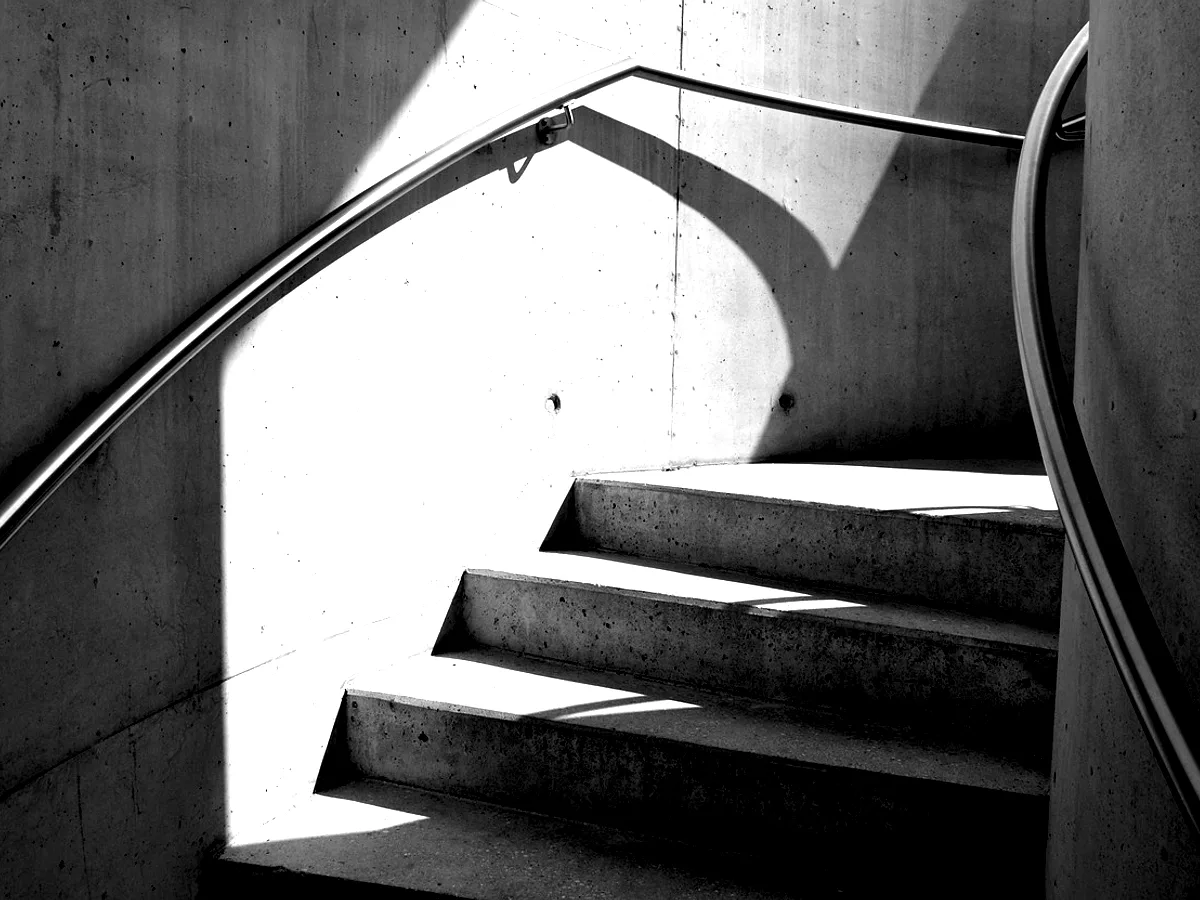 A white external stair reduced to three planes of light.